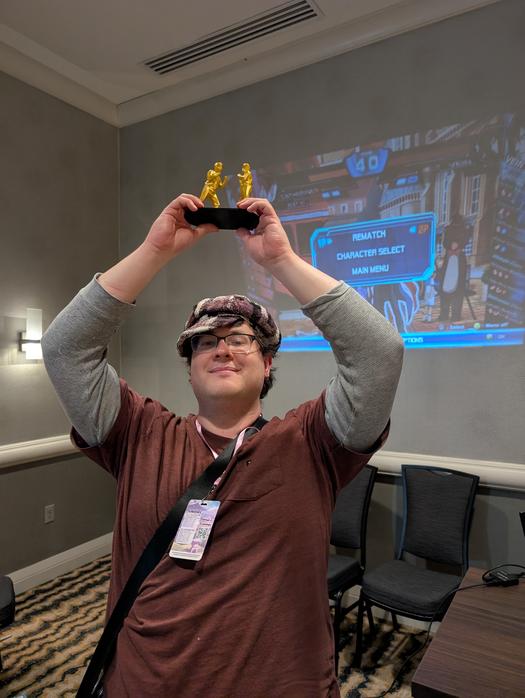 The champion of the mystery tournament, holding up the trophy. The final game of the tournament was Chaos Code: New Sign of Catastrophe.