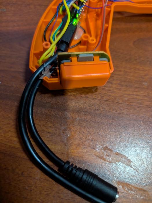USB cable and female 3.5mm aux jack hanging from the GunCon 2's original cable outlet.