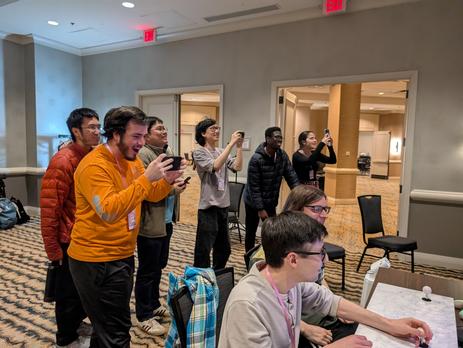 Much of the audience taking pictures and/or video of the Zoku Sonohigurashi vs. Touhou Universe 2 character select screen.