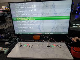 Game menu screen, with the arcade controllers lighting the green and red Select and Random buttons.