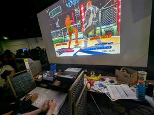 Buriki One on the Hyper NeoGeo 64 arcade platform. The game uses an inverted control scheme with the buttons on the left side and the joystick on the right, and the arcade controller has been turned upside-down to match.